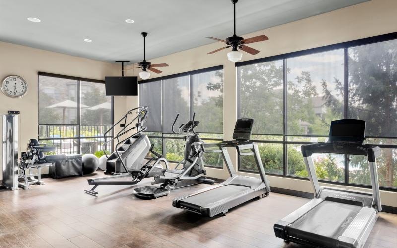 a room with treadmills and large windows