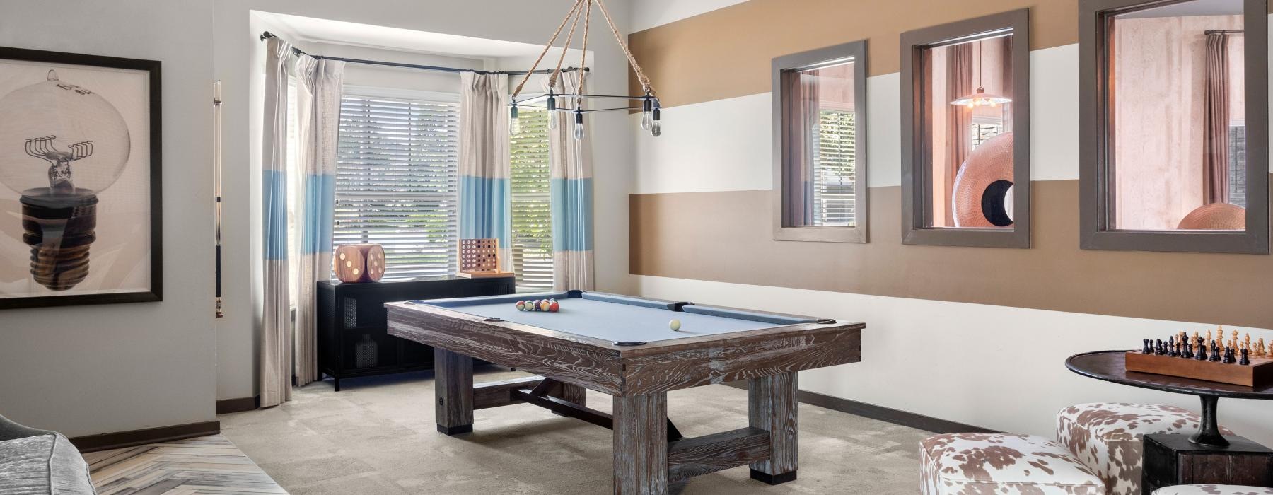 a room with a pool table and chairs